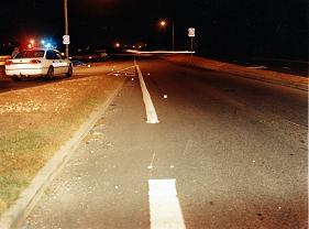 single skid mark on the road, other tire mark on the grassed area of the traffic island