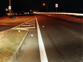 single skid mark on the road, other tire mark on the grassed area of the traffic island